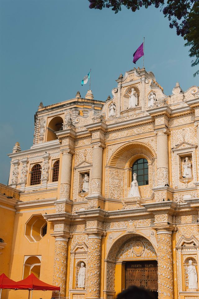 Aerial view of Antigua Guatemala's colonial rooftops, domed church and courtyards spreading toward green hills