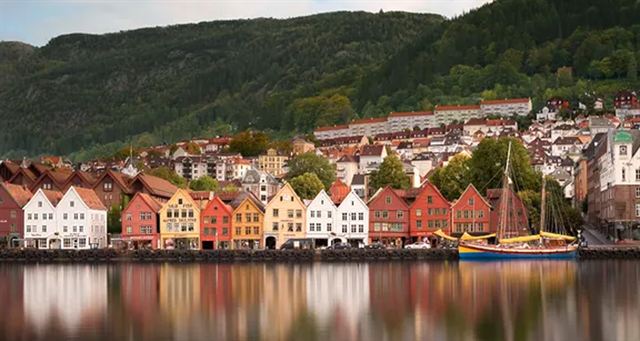 Colorful wooden Bryggen wharf houses in Bergen reflected in the calm harbor