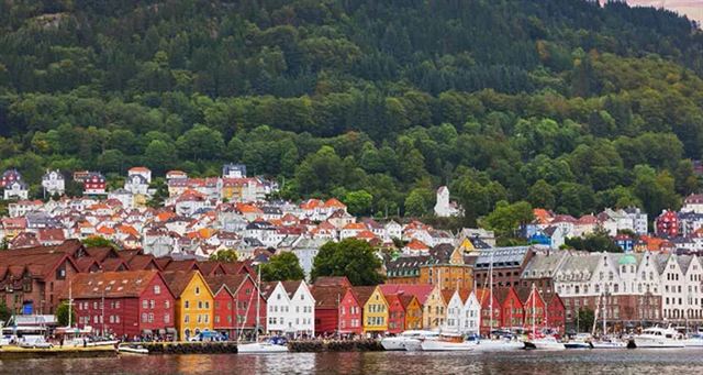 Bergen harbor with the Bryggen wharf houses and the town climbing the green hillside