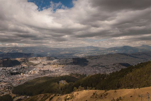 Wide view from Monserrate over the sprawling city of Bogota and surrounding mountains under dramatic clouds