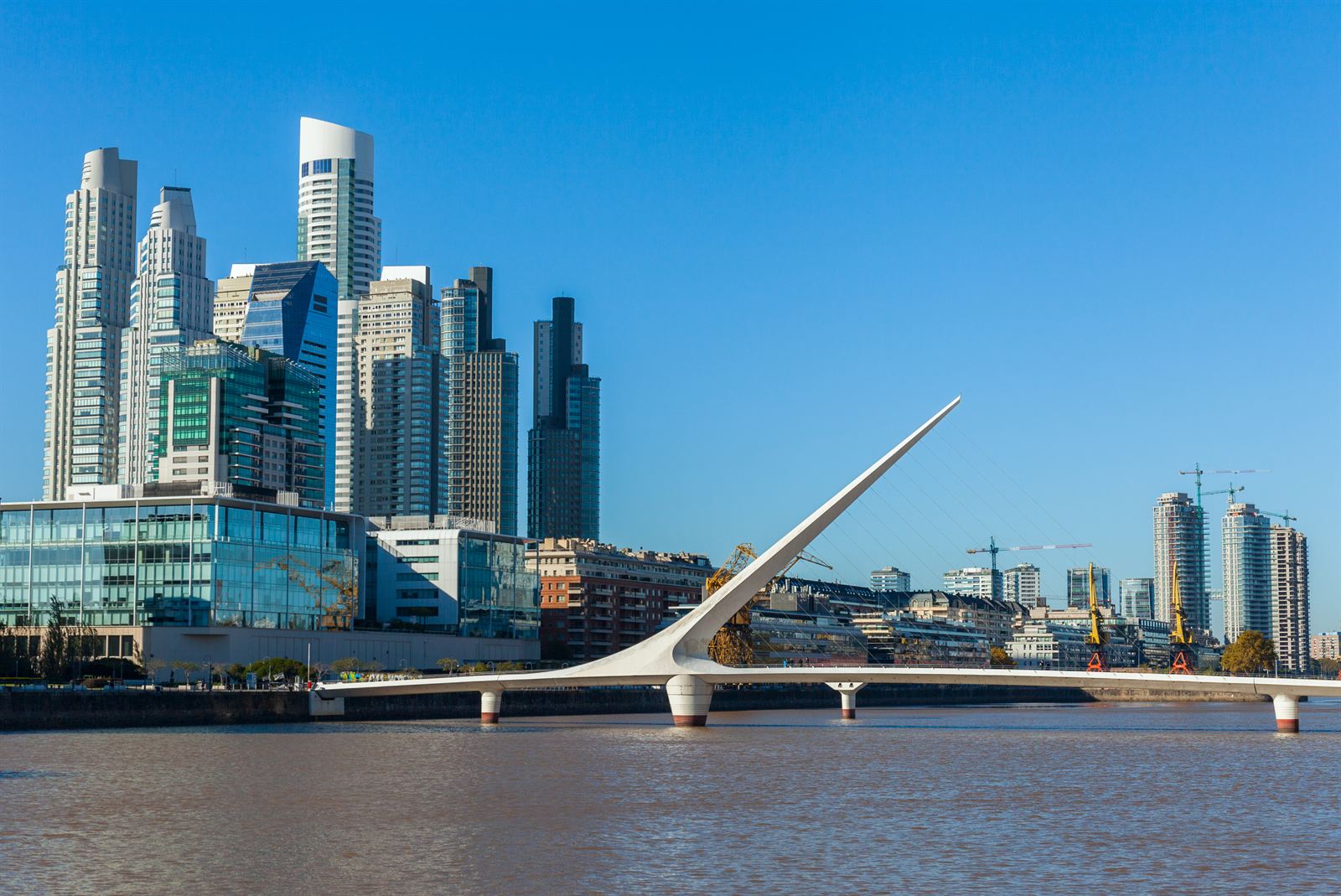 Puente de la Mujer footbridge and Puerto Madero glass towers under a blue sky, Buenos Aires