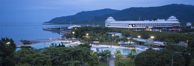 Cairns Esplanade and its swimming lagoon at dusk with hills across the inlet, Queensland