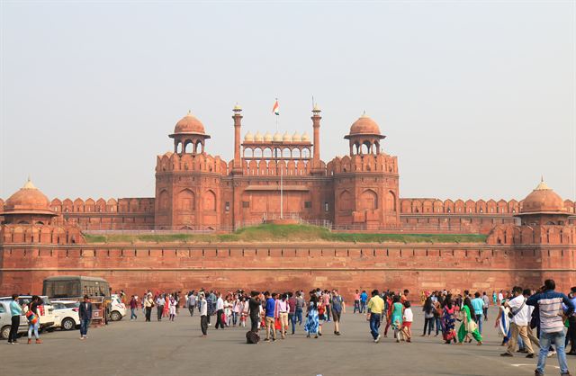 Red sandstone Lahori Gate of the Red Fort in Delhi with crowds of visitors in front