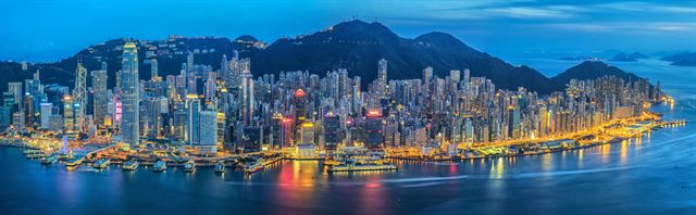 Hong Kong skyline and Victoria Peak lit at night across the harbour (wide panorama)