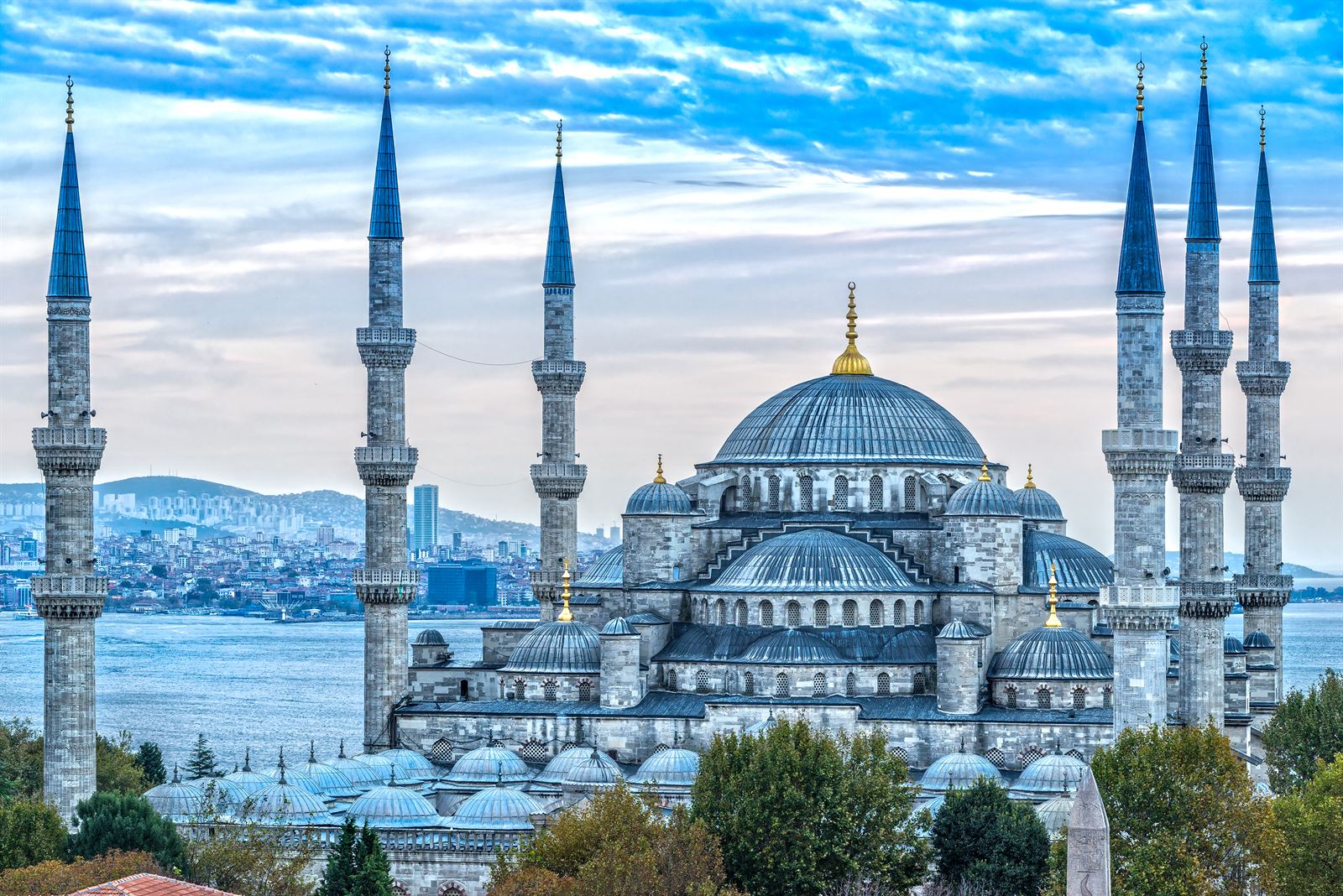 Blue Mosque in Sultanahmet with its domes and six minarets, Bosphorus waters behind