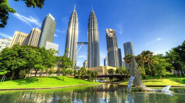 Petronas Twin Towers and Kuala Lumpur skyline above the lake at KLCC Park