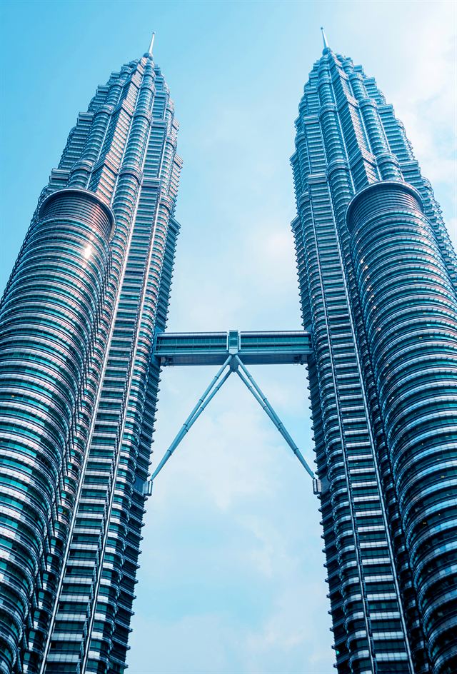 Petronas Twin Towers and their skybridge seen from below against a blue sky, Kuala Lumpur