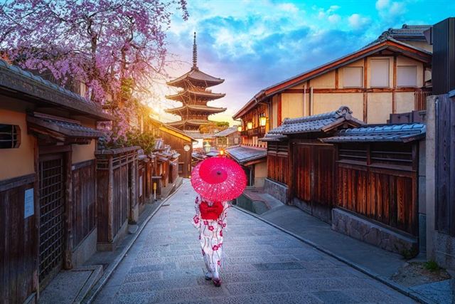 Woman with a red umbrella on a Higashiyama lane below the Yasaka Pagoda, Kyoto