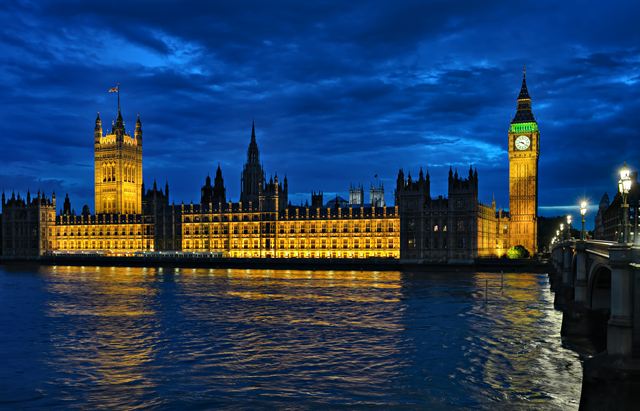 Houses of Parliament and Big Ben lit up at night across the Thames