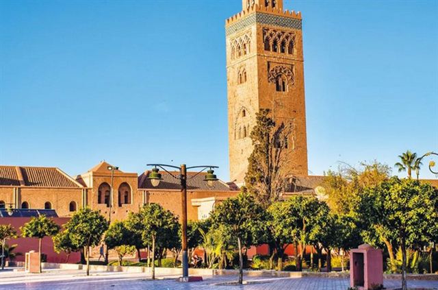 Koutoubia Mosque minaret rising above palm trees and gardens in Marrakech, Morocco