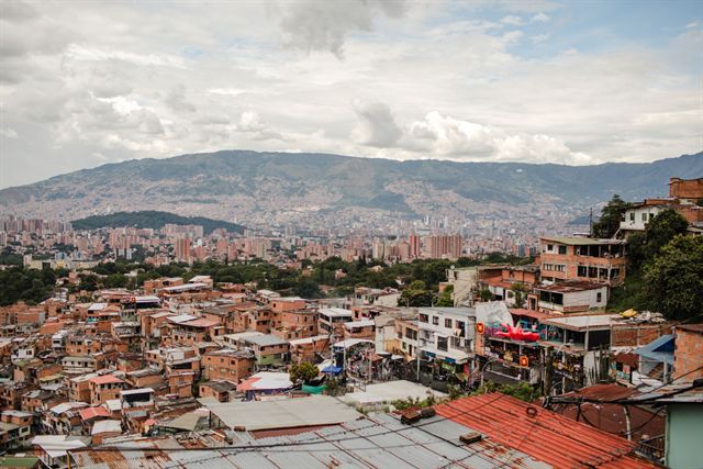 Colorful rooftops of Medellin hillside barrios with the city and valley mountains stretching behind