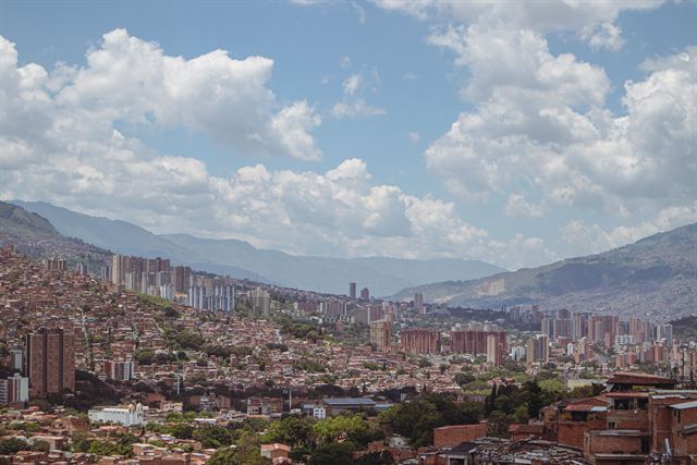 High-rise towers and dense neighborhoods of Medellin filling the valley below green mountains