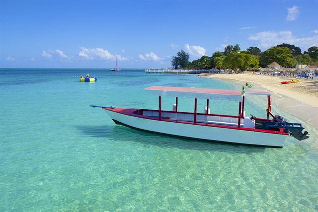 Glass-bottom boat floating in clear shallow water off Doctor's Cove Beach, Montego Bay