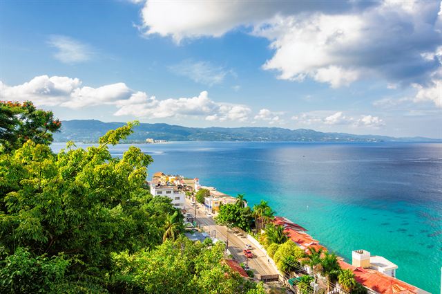 Elevated view over green trees to Montego Bay's shoreline, hotels and turquoise sea
