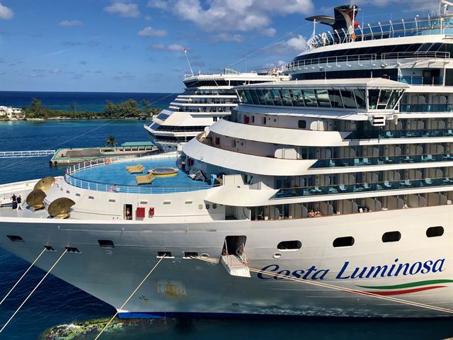 Costa Luminosa cruise ship moored at Nassau's cruise pier with another ship and the shoreline behind