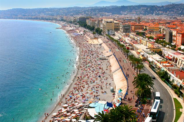 Curving beach and Promenade des Anglais along the turquoise Baie des Anges in Nice, France