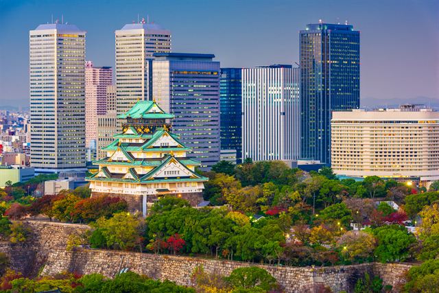 Osaka Castle keep on its stone walls framed by modern Osaka Business Park towers