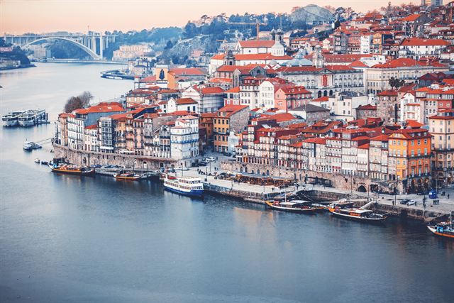 Porto old town and the Ribeira waterfront rising above the Douro river at dusk