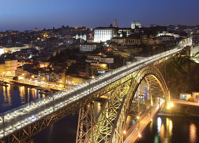 Dom Luis I iron bridge lit at night above the Douro and Porto old town