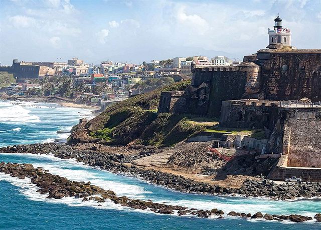 El Morro fortress walls and lighthouse on the rocky headland with Old San Juan's buildings behind