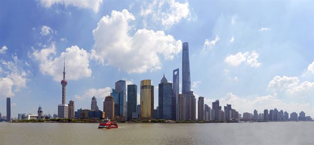 Panoramic Shanghai skyline of Pudong towers under white clouds across the Huangpu
