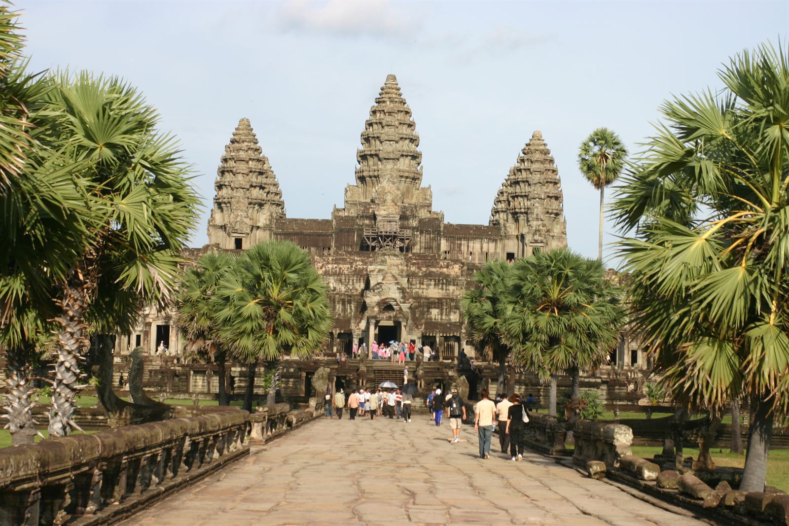 Causeway leading to the five towers of Angkor Wat framed by palm trees, Siem Reap