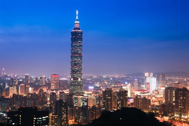 Taipei 101 tower lit at dusk above the glittering Taipei city skyline