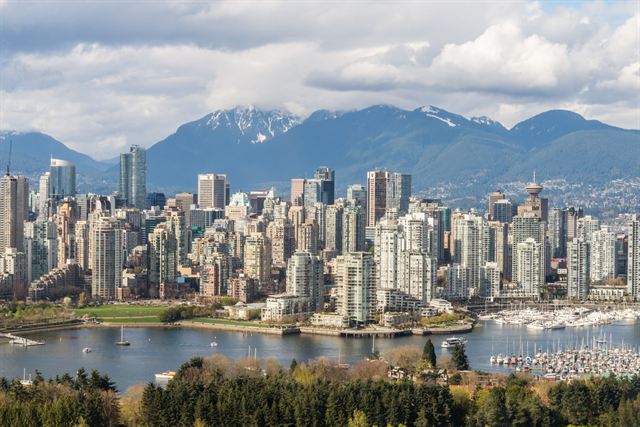 Downtown Vancouver high-rises and False Creek marina with the snowy North Shore mountains behind