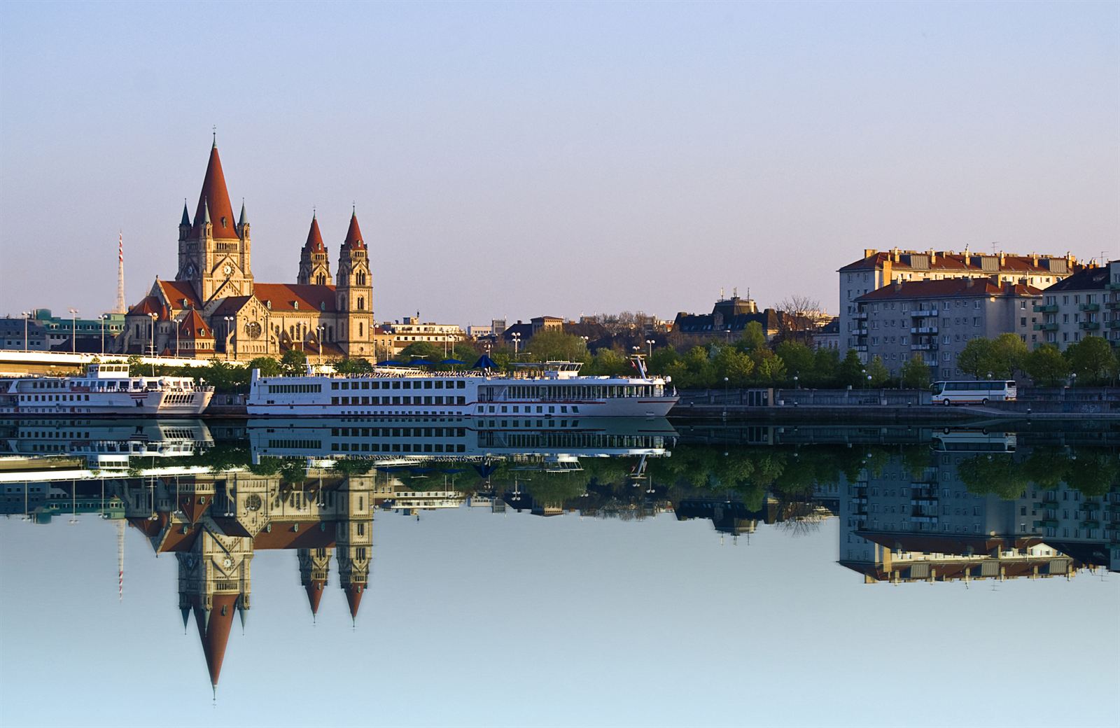 St. Francis of Assisi Church and river cruise ships reflected in the Danube at Vienna