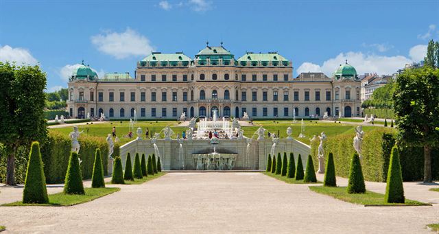 Upper Belvedere Palace in Vienna beyond formal gardens, clipped conifers and a fountain